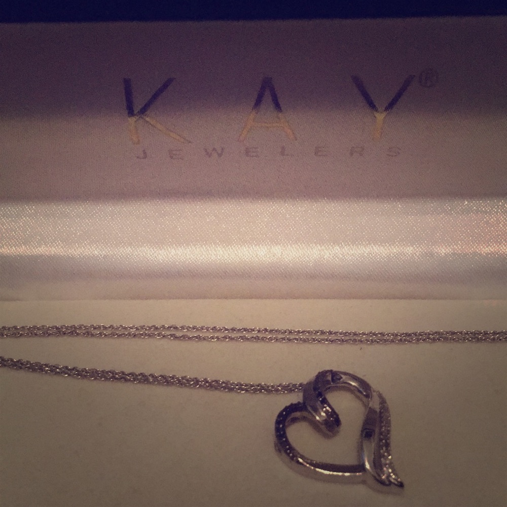 Heart shape necklace with dark colored diamonds.